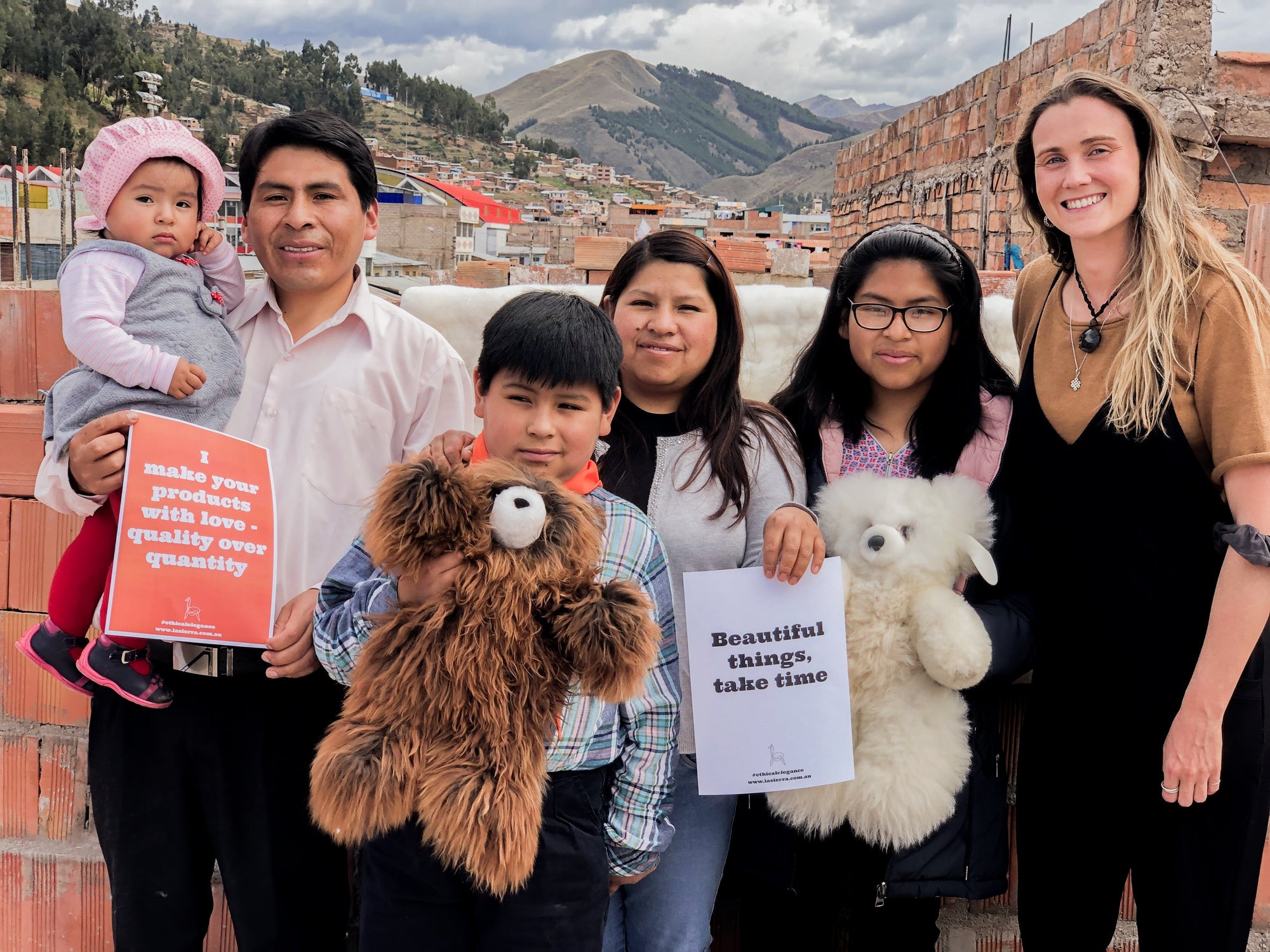 Family group outdoors with handmade stuffed animals and quality craftsmanship signs