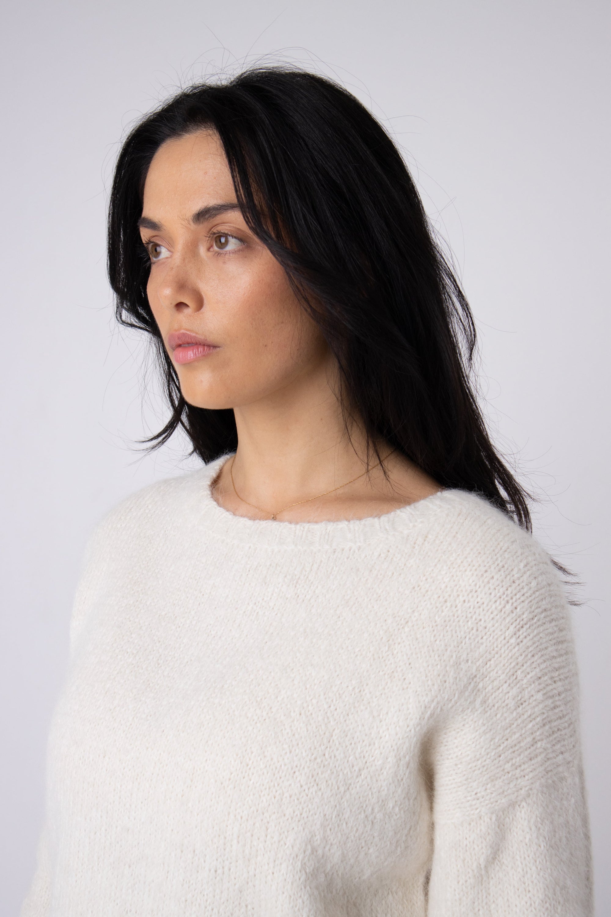 Woman wearing a soft white alpaca jumper, cozy knit sweater fashion