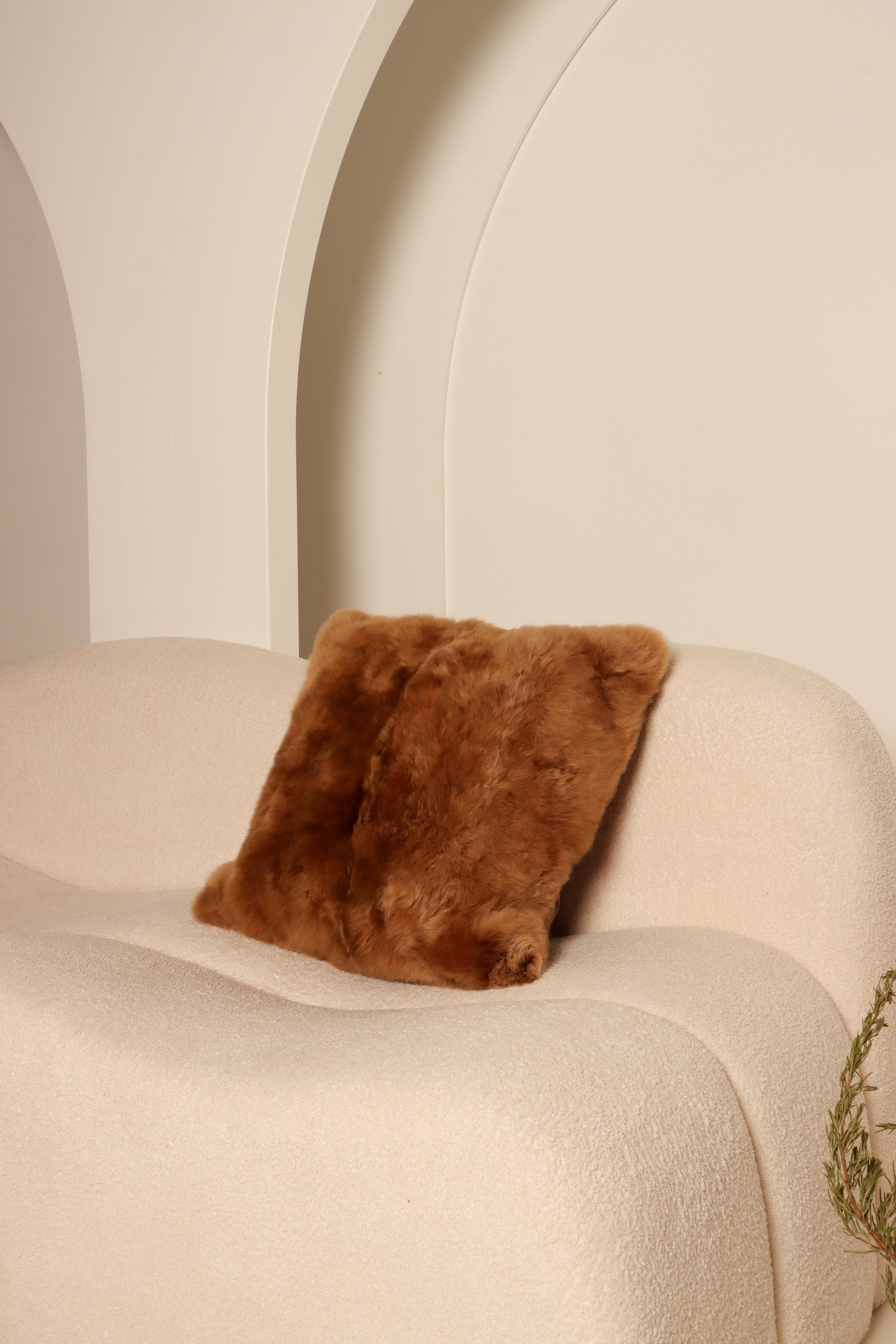 Alpaca fleece cushion covers in neutral tones on a modern sofa in a bright living room